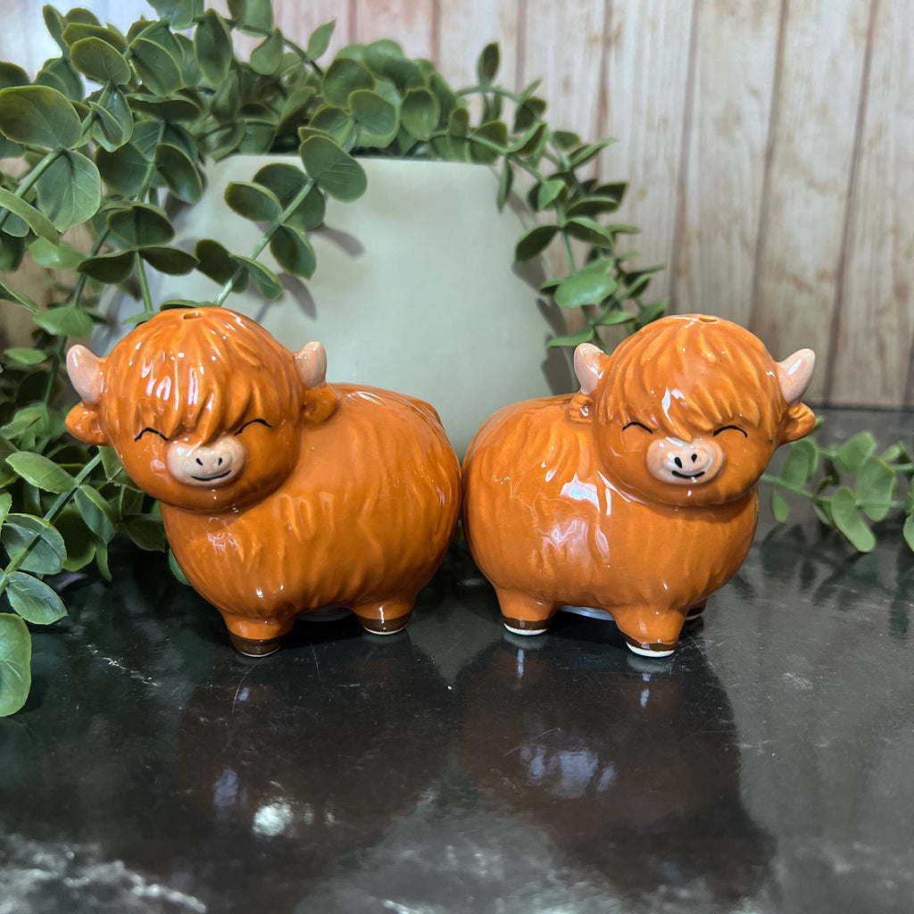 Highland cow salt and pepper shakers in ceramic, featuring cute expressions and rustic charm.